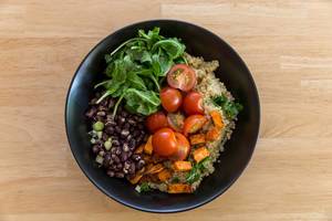 Top view of Cuban Quinoa Bowl by Hellofresh with sweet potatoes, cherry tomatoes, rocket and red beans