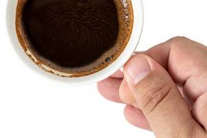 Top View of Cup of Black Coffee in the hand above white background (Flip 2019)