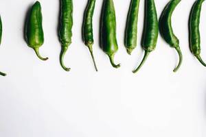 Top view of green chili peppers on white background. Details