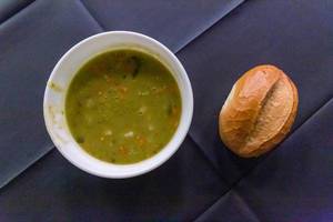 Top view of green vegetable soup with bread - warm meal at a German christmas market