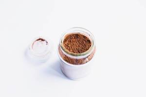 Top view of jar with cocoa powder on white background