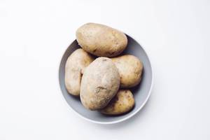 Top view of raw potatoes on white background.