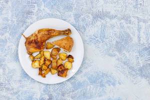 Top view of served Chicken Drumstick with Potatoes and Bread