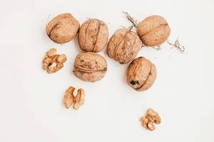 Top view of shelled and whole walnuts on white background