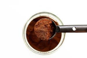 Top view of spoon of ground coffee and a jar of coffee on white background  Flip 2019