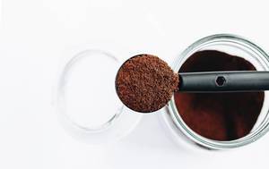 Top view of spoon with ground coffee