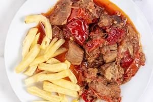 Top view of Traditinal meal Muckalica with Pork Meat and French Fries