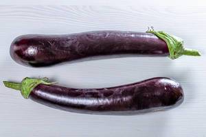 Top view of two purple eggplants on a white table (Flip 2019)