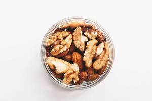 Top view of walnuts and almonds on white background.