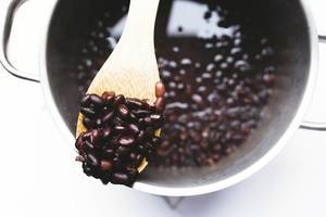 Top view of wooden spoon of cooked black beans