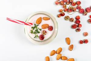 Top view of yogurt with strawberries and almonds on a white background (Flip 2020)