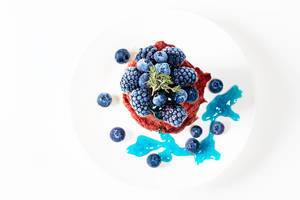 Top view, pancakes on a white plate with blueberries and mulberries (Flip 2019)