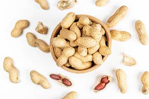 Top view, peanuts in a wooden bowl on a white background