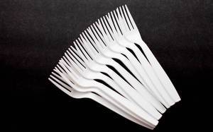 Top View Photo of Bunch of White Single Use Plastic Forks on Black Background