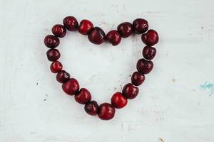 Top View Photo of Heart formed by Cherries on white Background