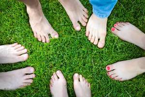 Top View Photo of People standing barefoot on Green Grass