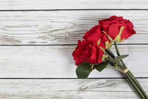 Top View Photo of Three Arificial Red Roses as a Bouquet of Flowers on White Wooden Table