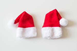 Top View Photo of two Christmas Santa Claus Hats on White Background