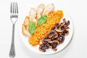 Top view plate with lentils, chicken and mushrooms on a white wooden background (Flip 2019)