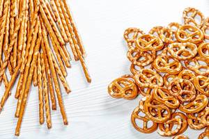 Top view salted straws and pretzels on white wooden background (Flip 2019)