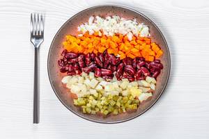 Top view sliced boiled carrots, beets, potatoes, pickles and onions (Flip 2019)