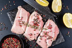 Top-view-steaks-with-spices-lemon-slices-and-a-knife-on-a-dark-background.jpg