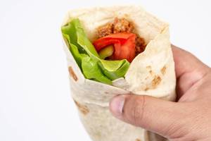 Tortilla with Minced meat Tomato and Lettuce in the hand (Flip 2019)