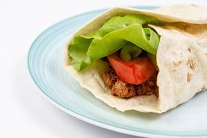 Tortilla with Minced meat Tomato Lettuce served on the plate