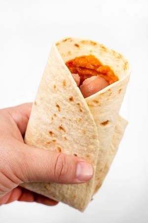Tortilla with Sausages in the hand above white background