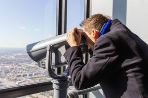 Tourist benutzt ein Aussichtsfernrohr in Downtown Chicago