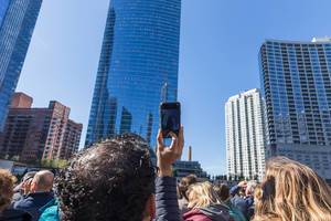Tourist fotografiert die Wolkenkratzer von Chicago während einer Sightseeing-Bootfahrt