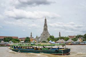 Touristenboot auf dem Chao Phraya Fluss in Bangkok vor dem Wat Arun, dem Tempel der Morgenröte
