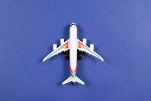 Toy plane on blue paper background