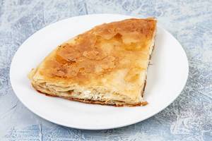 Traditional Balkan cheese pie Burek served on the plate (Flip 2019)