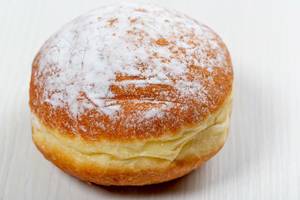 Traditional doughnut on white wooden background with powdered sugar