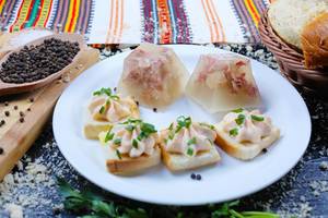 Traditionelle Balkanküche: Schweinefleisch in Aspik auf einem weißen Teller