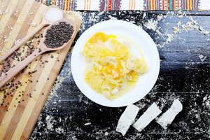 Traditionelles Rezept: Polenta mit Käse und Sahne in weißem Teller vor einem schwarzen Hintergrund
