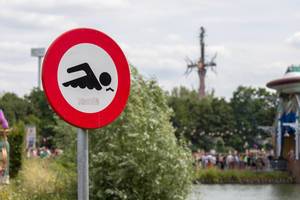 Traffic sign at the lake shows that swimming is prohibited at the Tomorrowland Festival
