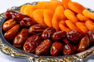 Tray with dried dates and dried apricots close-up