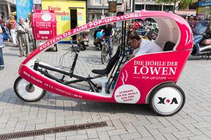 Tricycle with an ad for the pop up store Die Höhle der Löwen