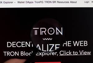 Tron-Logo am PC-Monitor, durch eine Lupe fotografiert