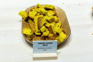 Tumeric-Cashew-Bread cut in pieces on a wooden tray
