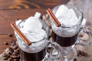 Two glass cups of coffee with whipped cream