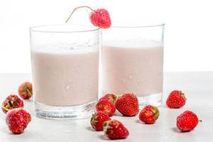 Two glasses of yogurt and fresh red strawberries