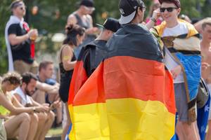 Two men are covered by German flags at Tomorrowlan festival in Belgium