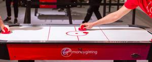 Two people playing air hockey