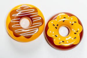 Two plastic donuts toys on white background. Top view