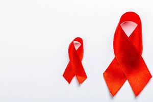 Two red ribbons on a white background. The concept of health care (Flip 2019)