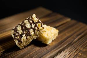 Two rice krispies blocks over a wooden surface