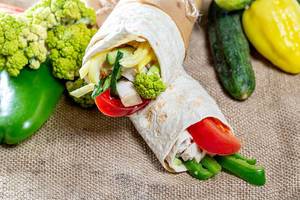 Two Shawarma with fresh vegetables on the background of burlap